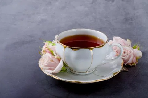 Tea time backdrop with vintage white porcelain tea cup, gentle pink roses on  Stock Photos