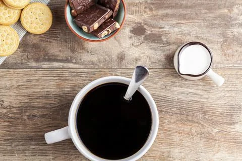 A tea time or coffee time concept with sandwich cookies, bars of chocolate ae Stock Photos