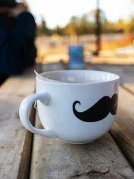Tea time outdoors featuring a illustrated mug with tea bag tag during golde Photos