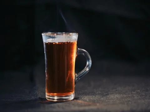 Tea in transparent Cup on a dark background. Slow motion Stock Footage 73672298