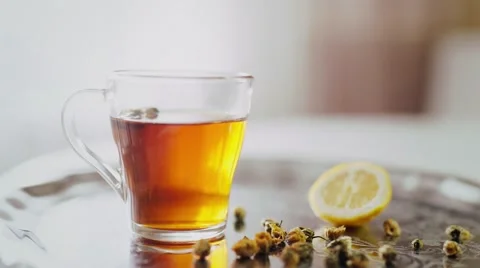 Tea in a transparent cup with lemon and flowers Stock Footage 55857340