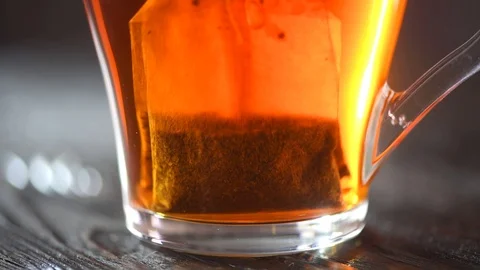  Tea in transparent glass cup over black wooden background Vídeo Stock 101895409