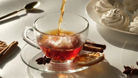 Tea in a transparent mug or cup on a white, light background with marshmallow or Stock Footage 197677583
