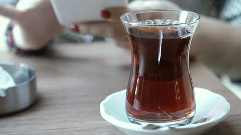 Tea. Turkish tea on the background of hands with a mobile phone Stock Footage 100083482