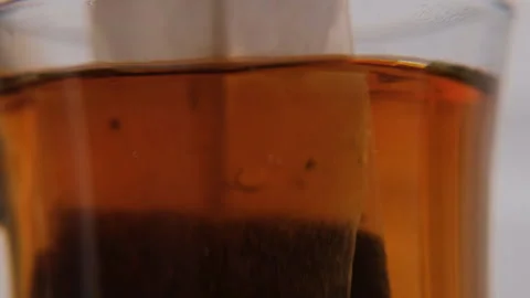 Teabag brewing in glass cup, macro closeup 스톡 동영상 321952831