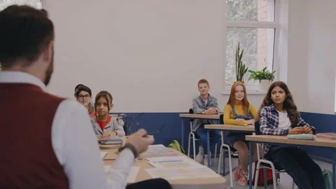 Teacher actively talking to elementary kids and children laugh with him Stock-Footage 162732932