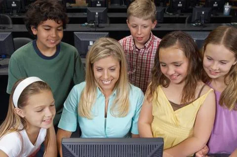 Teacher And Children Using Computer Stock Photos