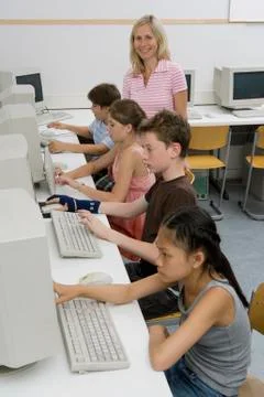 A teacher and four pre-adolescent children in a computer lab Stock Photos