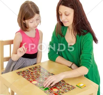 The teacher and the girl at the table studying the cards Stock Photos
