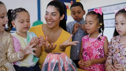 Teacher and group of children learning about volcanos at science kindergarten  Stock Footage 276483991