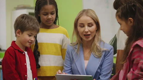 Teacher and pupils playing educational game on tablet during school lesson Stock Footage 335683602