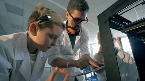Teacher and pupils work with 3D printer using tablet. Stock Footage 93565124
