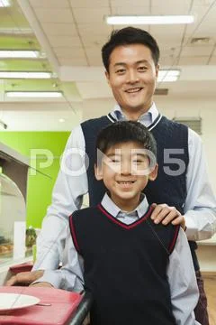 Teacher and school boy portrait in school cafeteria Stock Photos