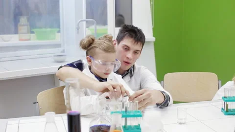 Teacher and schoolboy make experiments in the chemistry class Stock Footage 86841349
