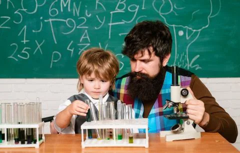 Teacher and schoolboy using microscope in class. Wunderkind. Science and Stock Photos