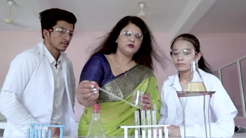 Teacher and student performing experiment in Chemistry lab Video stock 157057549
