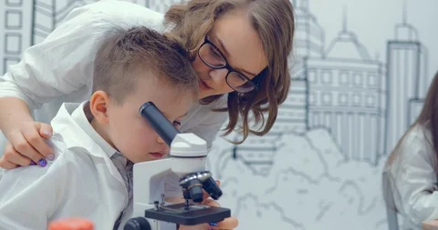 Teacher and student prepare a microscope, adjust the microscope for work Stock Footage 86150512