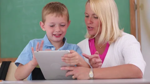 Teacher and student use digital tablet in classroom Stock Footage
