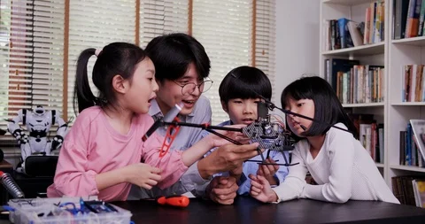 Teacher and student work on a programable robot at school. Stock Footage 109532945