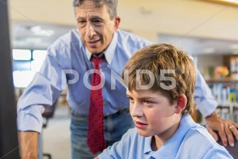 Teacher And Student Working At Computer