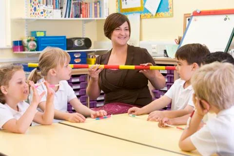 Teacher and students in math class with measuring stick Stock Photos