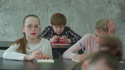 Teacher is angry because school boy playing games on smartphone during class Vídeos de archivo 77738779