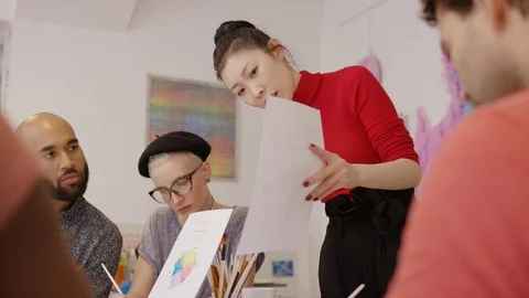 Teacher in art class explains a worksheet to students Video stock 111798974