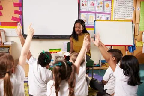 Teacher Asks Elementary School Pupils Question In Classroom Foto stock