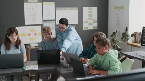 Teacher Assisting her Students During Programming Lesson in School Stock Footage 317642183