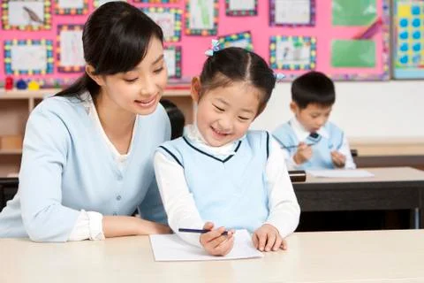 Teacher assisting student in class Stock Photos