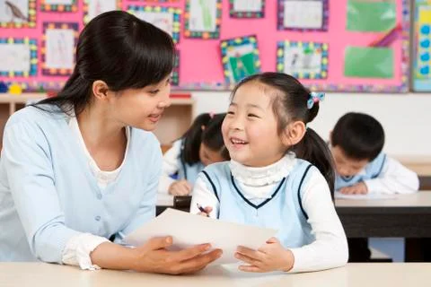 Teacher assisting student in class Stock Photos