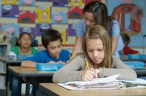 Teacher Assisting Students Stock Photos