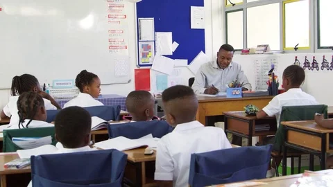 Teacher checking attendance list in elementary school class Stock Footage 78933731