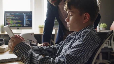 Teacher Checking on Boy Working on Tablet at Programming Class Stock Footage 278126412