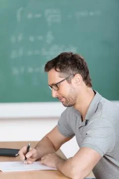 Teacher checking examination papers at bench Stock Photos