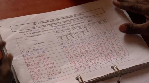 Teacher checking the grades and exam results of students in rural school, Africa Stock Footage 230078675