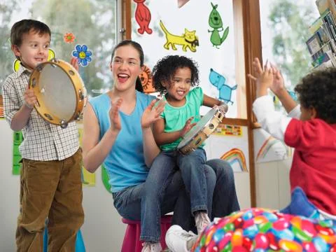 Teacher With Children Playing Music In Class Stock Photos