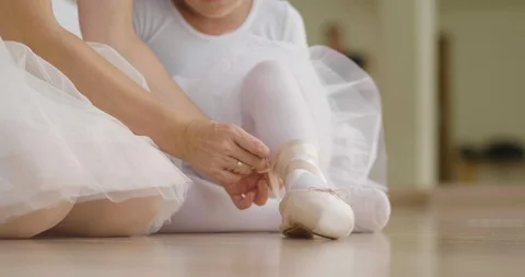 A teacher of classical dance teaches some steps to his young student. Video stock 114735730