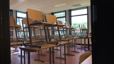 Teacher closes door empty classroom, coronavirus Covid-19 school closures Stock Footage 130175903