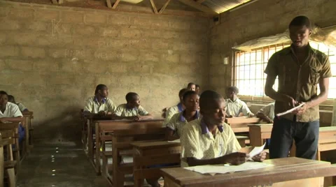 TEACHER COLLECTING PAPERS FROM STUDENTS IN CLASSROOM Stock Footage 60627450