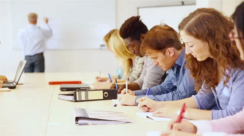 Teacher in college class writing on whiteboard Stock Footage 33466979