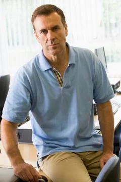 Teacher by computer terminals smiling (high key) Stock Photos