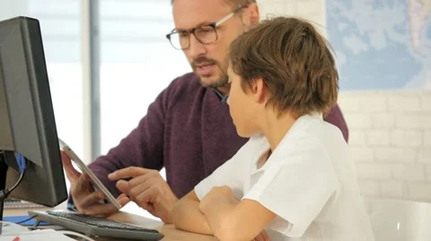 Teacher in computing class assisting kid with tablet Video stock 59761828