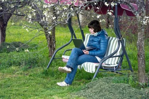 Teacher conducts a lesson on the Internet while sitting in the garden on an Foto stock