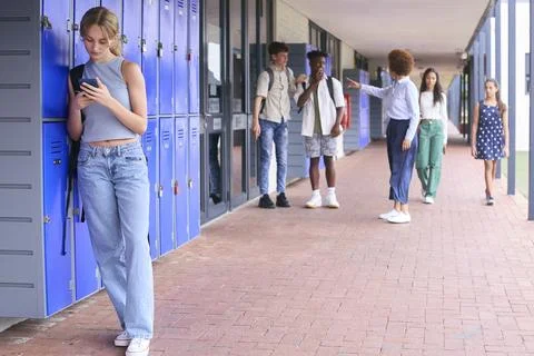 Teacher Confronting Students Teasing Or Bullying Unhappy Teenage Girl Outdoors Stock Photos