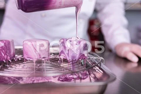 Teacher of cookery school showing cooking cakes with mirror icing Stock Photos