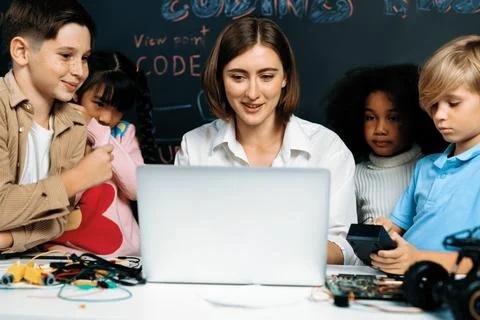 Teacher demonstrate attentive children to code robots in STEM class. Erudition. Stock Photos