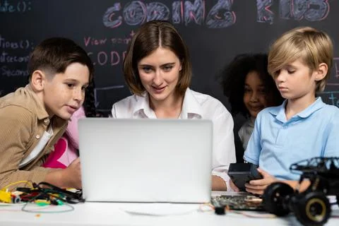 Teacher demonstrate attentive children to code robots in STEM class. Erudition. Stock Photos