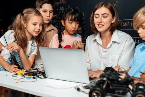 Teacher demonstrate attentive children to code robots in STEM class. Erudition. Stock Photos