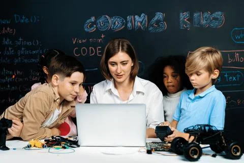 Teacher demonstrate attentive children to code robots in STEM class. Erudition. Stock Photos